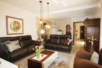 Wohnzimmer mit Blick auf den gekachelten Grundofen, der wohlige Wärme spendet